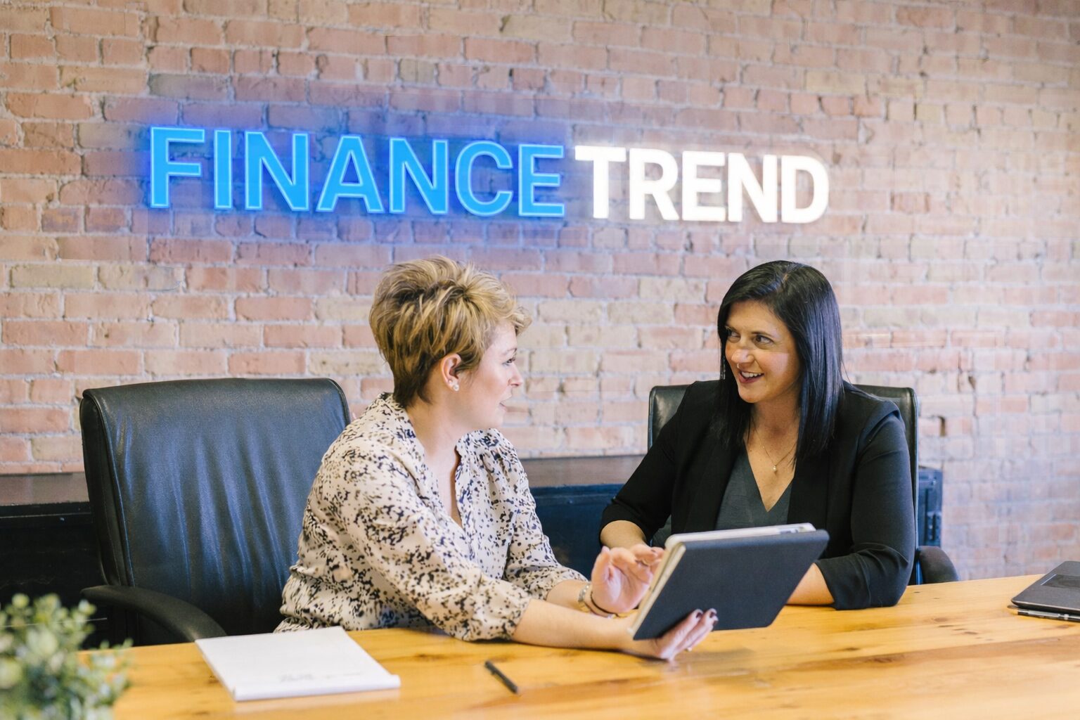 Zdjęcie Janiny i Gosi na tle loga Finance Trend